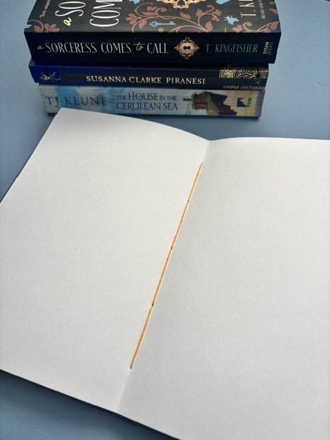 A5 Coptic stitch sketchbook | 48 pages | Blue book cloth cover | Yellow Bookworm | Elastic closure | Hand stitched