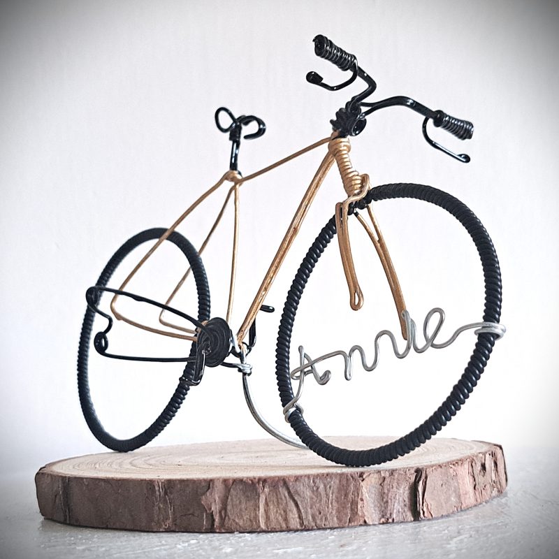 Handmade, gold colour, road style wire bicycle sculpture. Approximately 9cm long 4.5cm high, personalised with a name written in wire and set into the front wheel.