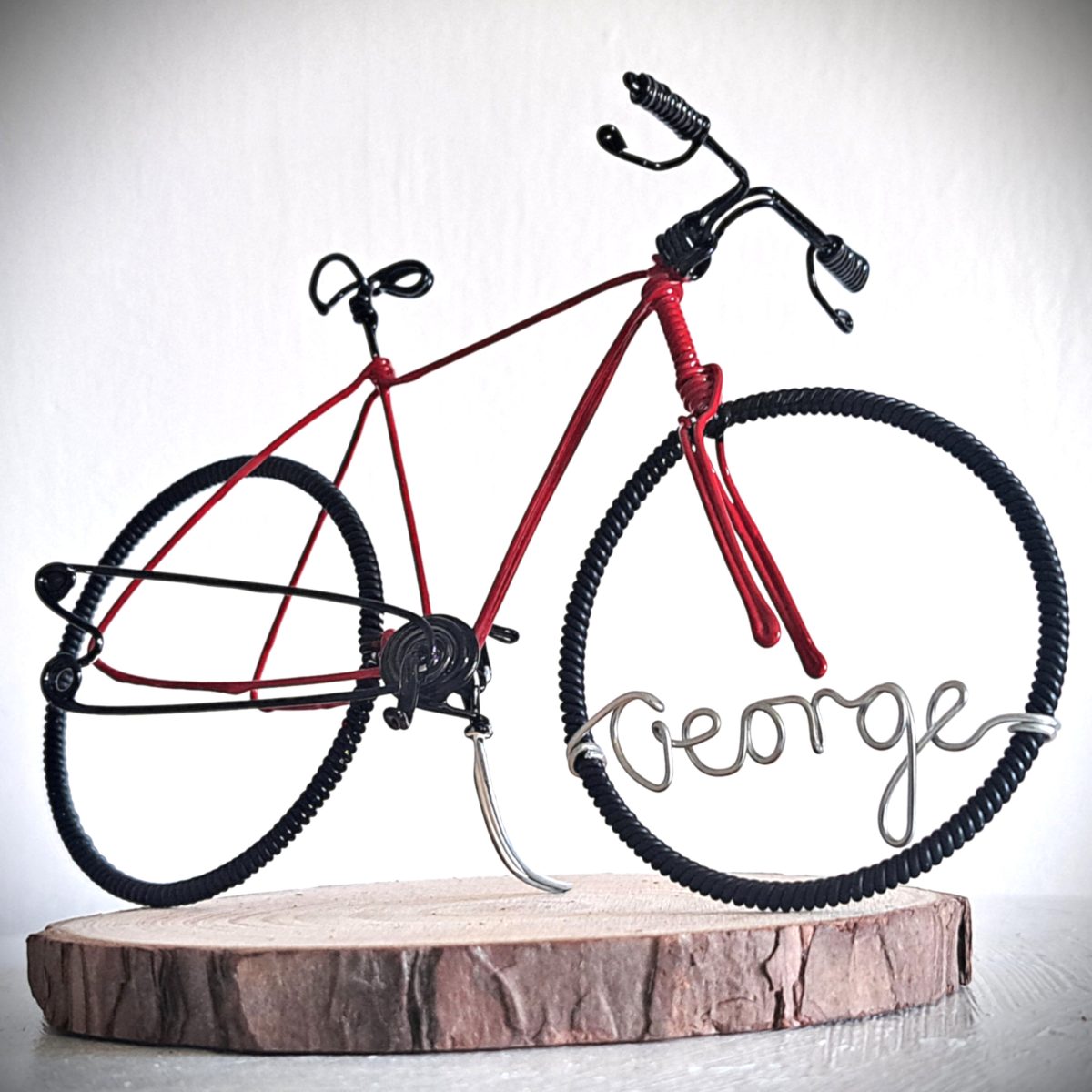 Handmade, red colour, road style wire bicycle sculpture. Approximately 9cm long 4.5cm high, personalised with a name written in wire and set into the front wheel.