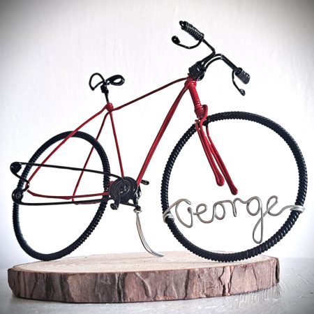 Handmade, red colour, road style wire bicycle sculpture. Approximately 9cm long 4.5cm high, personalised with a name written in wire and set into the front wheel.