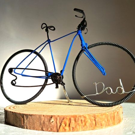 Handmade, blue colour, road style wire bicycle sculpture. Approximately 9cm long 4.5cm high, personalised with a name written in wire and set into the front wheel.