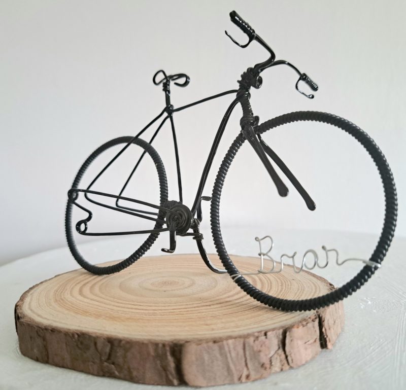 Handmade, black colour, road style wire bicycle sculpture. Approximately 9cm long 4.5cm high, personalised with a name written in wire and set into the front wheel.