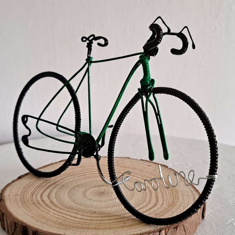 Handmade, green colour, curved handle bars wire bicycle sculpture. Approximately 9cm long 4.5cm high, personalised with a name written in wire and set into the front wheel.