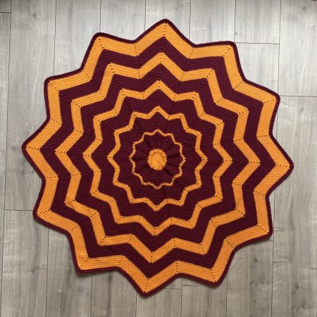 Crochet star shaped blanket in plum and bright orange