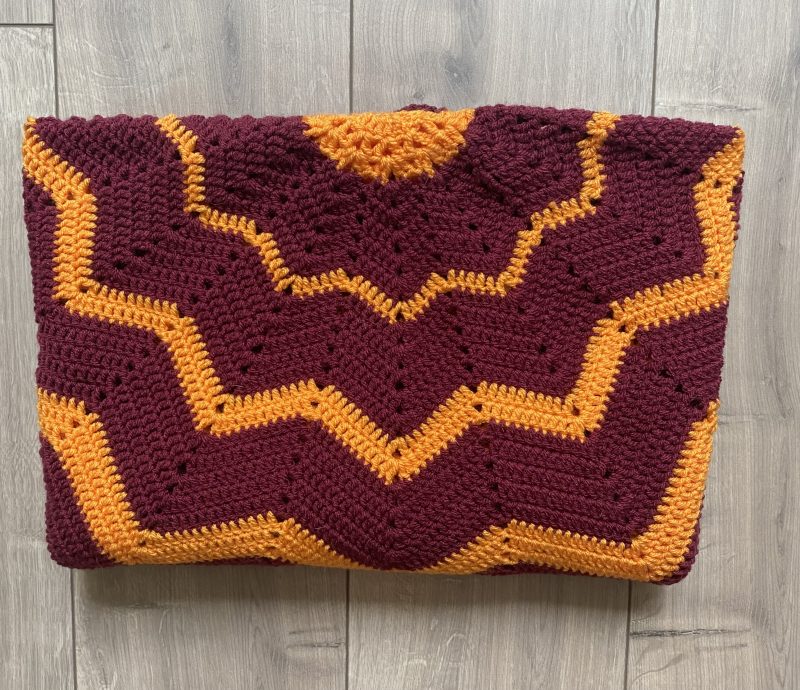 Crochet star shaped blanket in plum and bright orange
