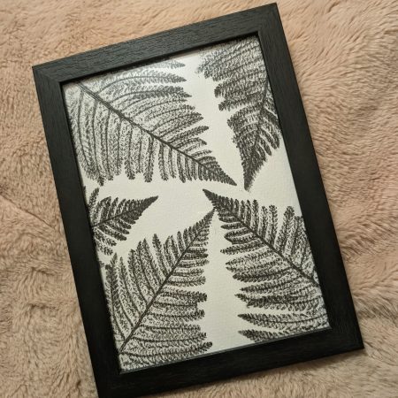 Framed fern print in a simple black frame