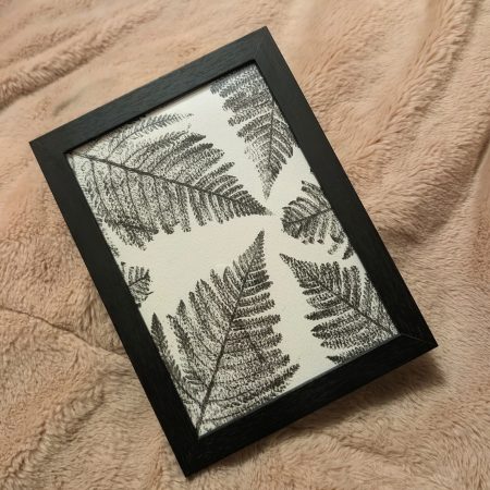 Framed fern print in a simple black frame
