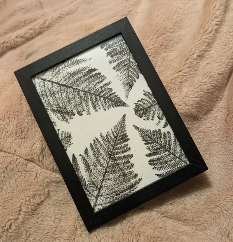 Framed fern print in a simple black frame