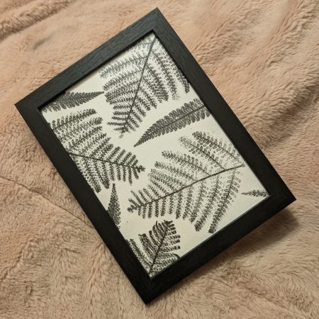 Framed fern print in a simple black frame