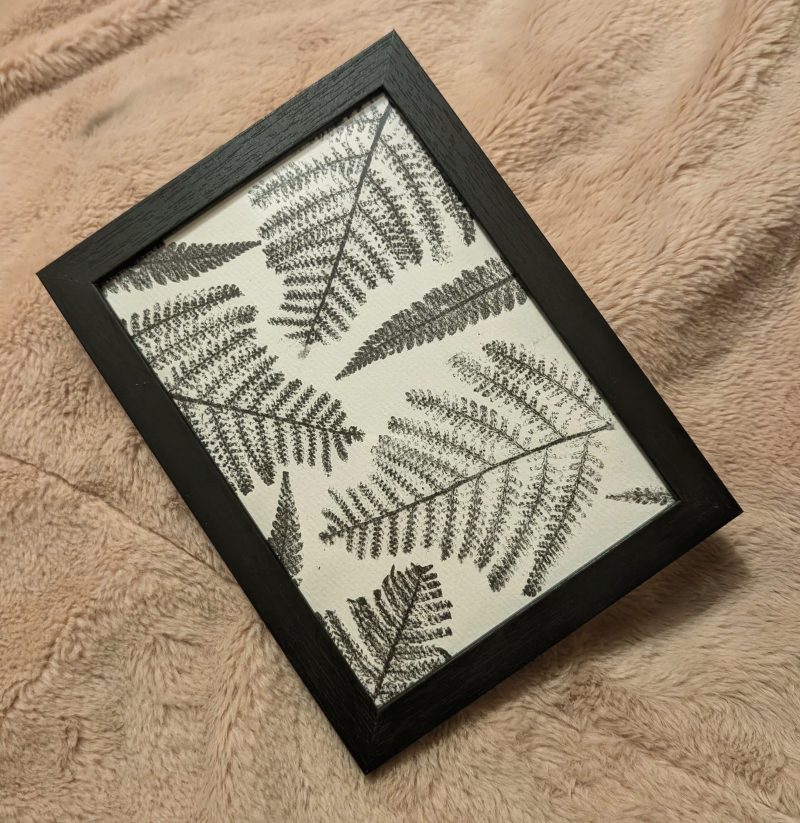 Framed fern print in a simple black frame