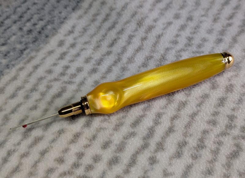 Seam ripper-unpicker made from bright yellow shimmering acrylic
