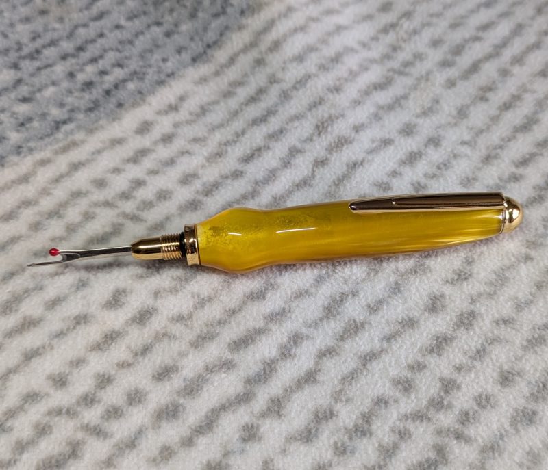 Seam ripper-unpicker made from bright yellow shimmering acrylic