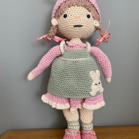 Handmade Crochet Lily the Doll, with a Pink dress and green apron.