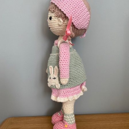 Handmade Crochet Lily the Doll, with a Pink dress and green apron.