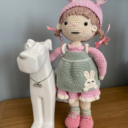 Handmade Crochet Lily the Doll, with a Pink dress and green apron.