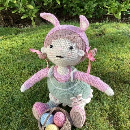 Handmade Crochet Lily the Doll, with a Pink dress and green apron.