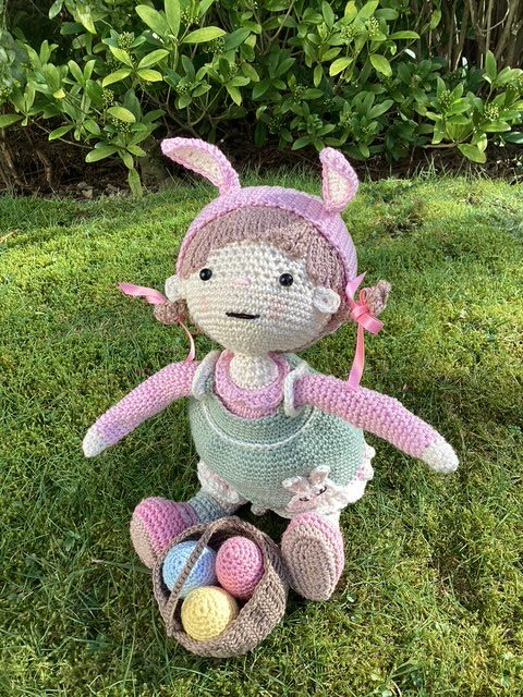 Handmade Crochet Lily the Doll, with a Pink dress and green apron.