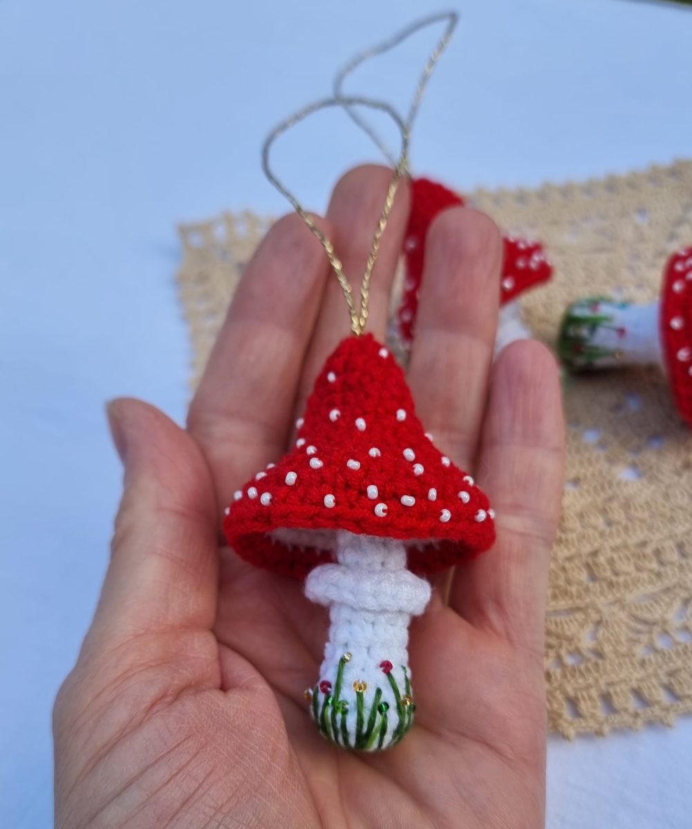 A small crocheted red and white toadstool decoration held in a hand