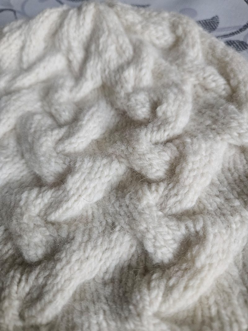 Handknitted 100% wool cabled hat.
