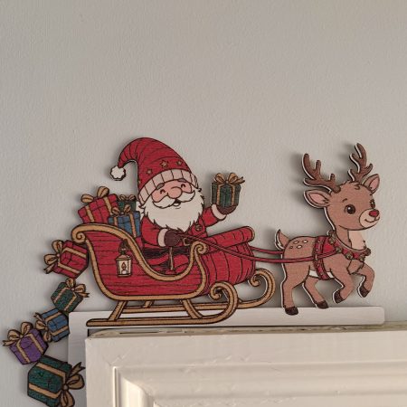 Full-colour Santa in a red sleigh with a reindeer and colourful presents around the upper left corner of a door frame.
