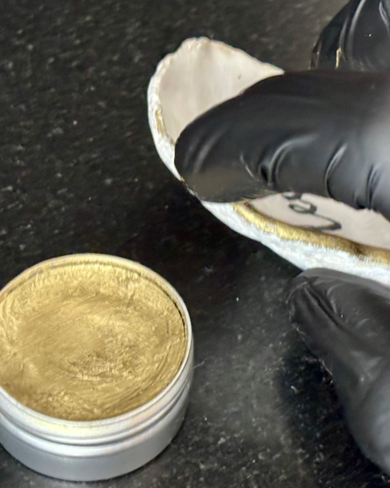 applying optional rich gold metallic gilding wax to the rim of a SHUCKED oyster shell according to the customer’s preferences