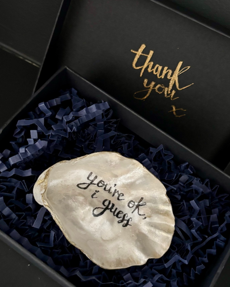 a SHUCKED shell lying in its gift box with a thank you message on the underside of the lid