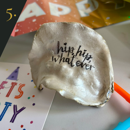 SHUCKED's oyster shell edition no.5, with message "hip, hip, whatever"